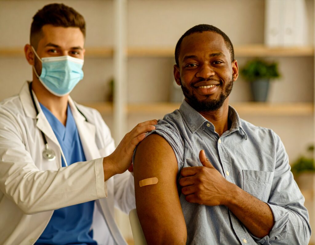 Firefly_professional-nurse-vaccinating-african-american-businessman-in-office, mirando a la c 662368